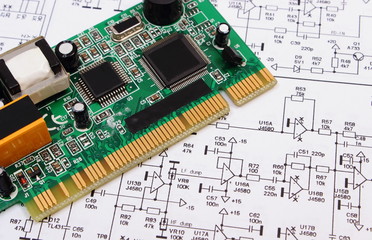 Printed circuit board lying on diagram of electronics, technology