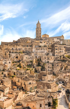 panoramic view of typical stones (Sassi di Matera) and church of Matera UNESCO European Capital of Culture 2019 under blue sky