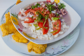 Ceviche mixto (accompanied by vegetables and patacons) is a popular meal in Ecuador