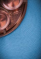Vintage coppery tray and tea cups on blue table cloth