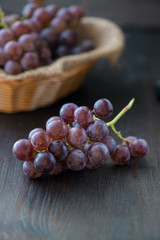 Bunch of grapes in the basket on wooden table