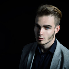 Portrait of beautiful charming young man with blue eyes and fair