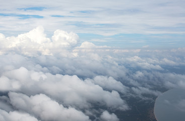 Obraz na płótnie Canvas Aerial view on clouds and blue sky from airplane window