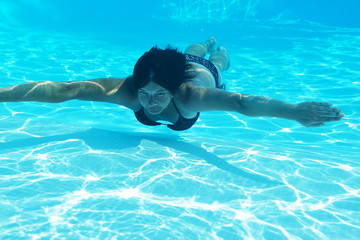 woman swimming underwater in pool