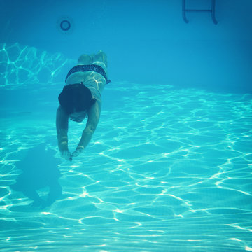 woman swimming underwater in pool