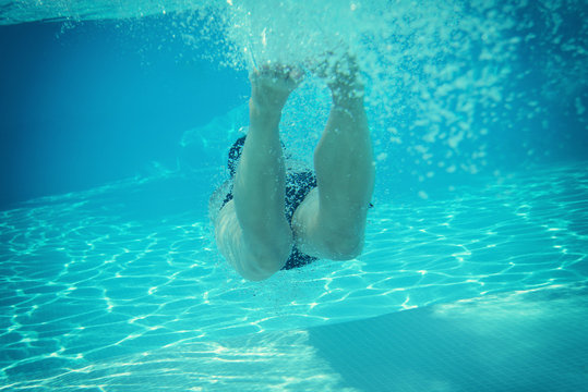 woman swimming underwater in pool, image toned