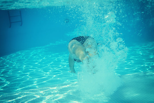 woman swimming underwater in water pool, image toned