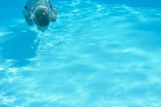 woman swimming underwater in water pool