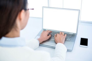Fototapeta premium Rear view of businesswoman using laptop 
