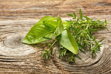 Green basil and thyme isolated on the wooden background
