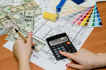 Architect's work space during work with technical drawing and color samples, dollar, notepad, calculator