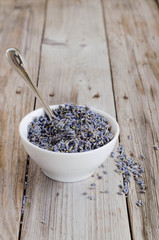  a white cup of dried lavender with stainless tea spoon
