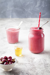 Cherry smoothie, coconut milk, yogurt and honey . Stone background