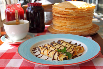 rolled pancakes on a plate with honey and powdered sugar