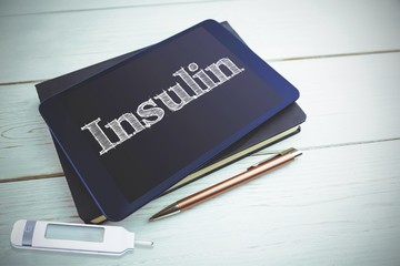 Insulin against view of a book and tablet lying on desk