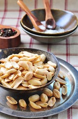 Peeled peanuts in a sea salt on an iron tray