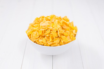 Corn flakes bowl on white wooden
