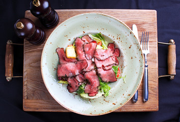 salad of meat on a plate, cut into thin slices