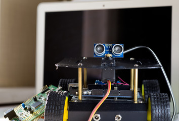 Fototapeta premium robot on wheels, a laptop and a printed circuit board