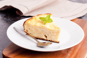 piece of cottage cheese pie with mint on a plate, closeup
