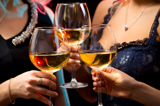 Women's hands with crystal glasses of wine