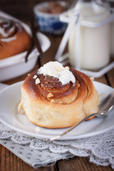 Homemade glazed cinnabons with cinnamon and almonds, american kitchen. Closeup.