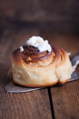 Homemade glazed cinnabons with cinnamon and almonds, american kitchen. Closeup.