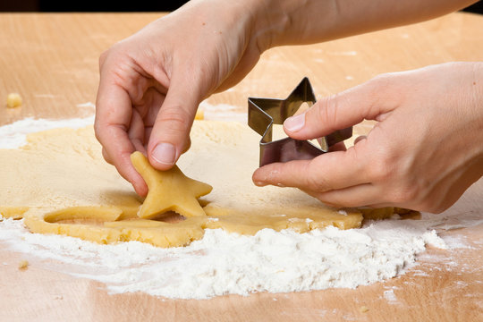 hands making cookies from dough at home