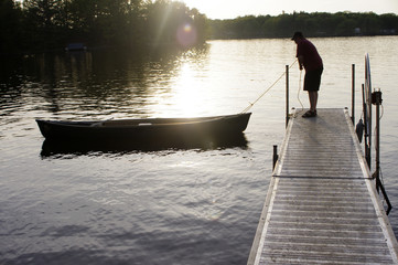 man pulling canoe to dock