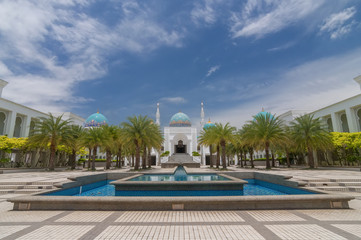 Obraz na płótnie Canvas Scenery of Mosque Albukhary located in Alor Star, state of Kedah, Malaysia with its fountain and squares in the foreground and blue sky with clouds in the background.