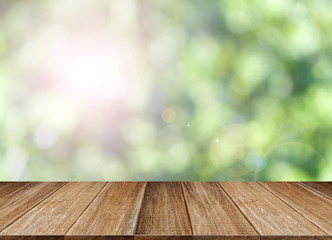 Wood table top on green bokeh and lens flare background