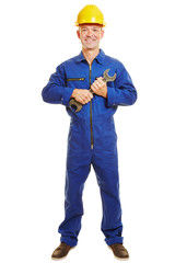 Installateur im Blaumann hält Maulschlüssel