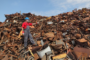 Recycling industry, worker gesture at heap of old metal
