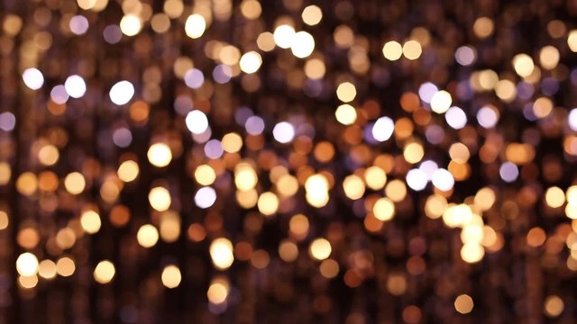 Abstract glittering lights, gold background, a real shot video in the blur