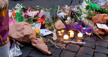 Flowers and lit candles in front of the French Embassy in Piazza