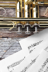 Trumpet with sheet music on rusty wooden boards