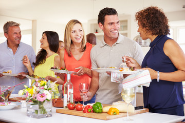 Group Of Mature Friends Enjoying Buffet At Dinner Party