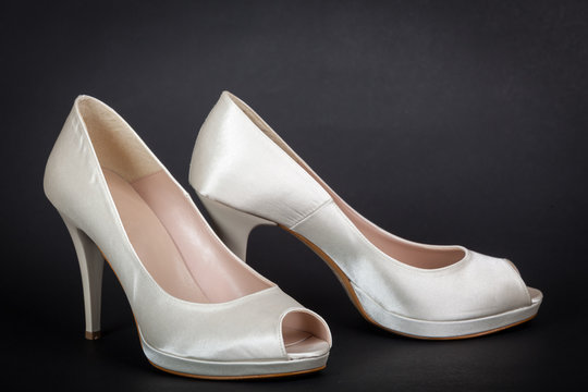 elegant white female shoes on dark background