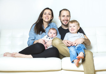 Young happy family with two children at home