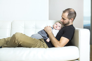 Father with baby on the sofa taking good time