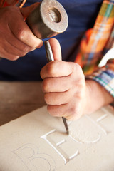 Close Up Of Stone Mason At Work On Carving In Studio