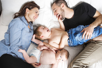 Happy family lying in bed 