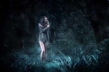 Fototapeta na wymiar Frightened girl in a dark forest