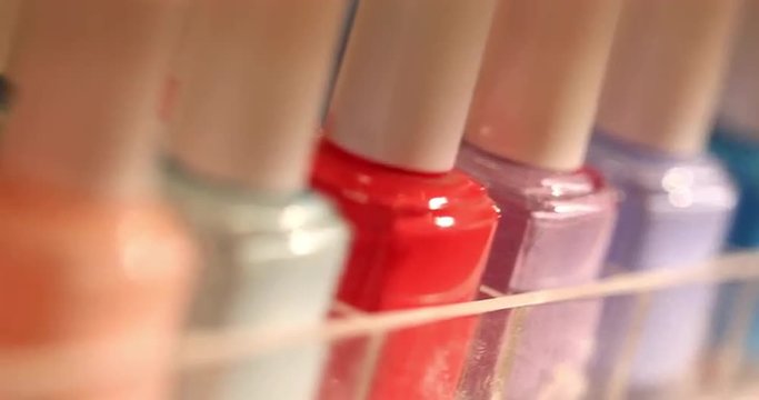 Nail Polish Bottles Macro Dolly. camera moves back on a row of nail polish colors. macro close up shot
