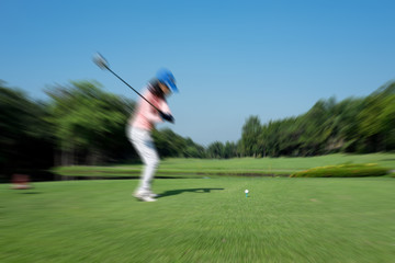 Motion blur golfer swinging driver club