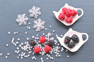 Raspberries  and blackberries tea with sugar crystals  and snowflake 