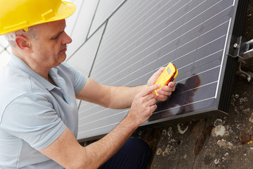 Engineer Installing Solar Panels On Roof Of House