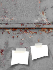 Two ripped pieces of paper with tape on rusty blue metal background