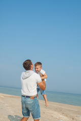 Father and his son having fun on the beach