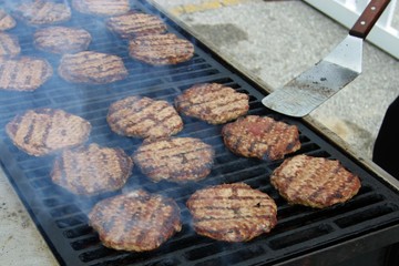 Burgers cooking on a large outdoor grill